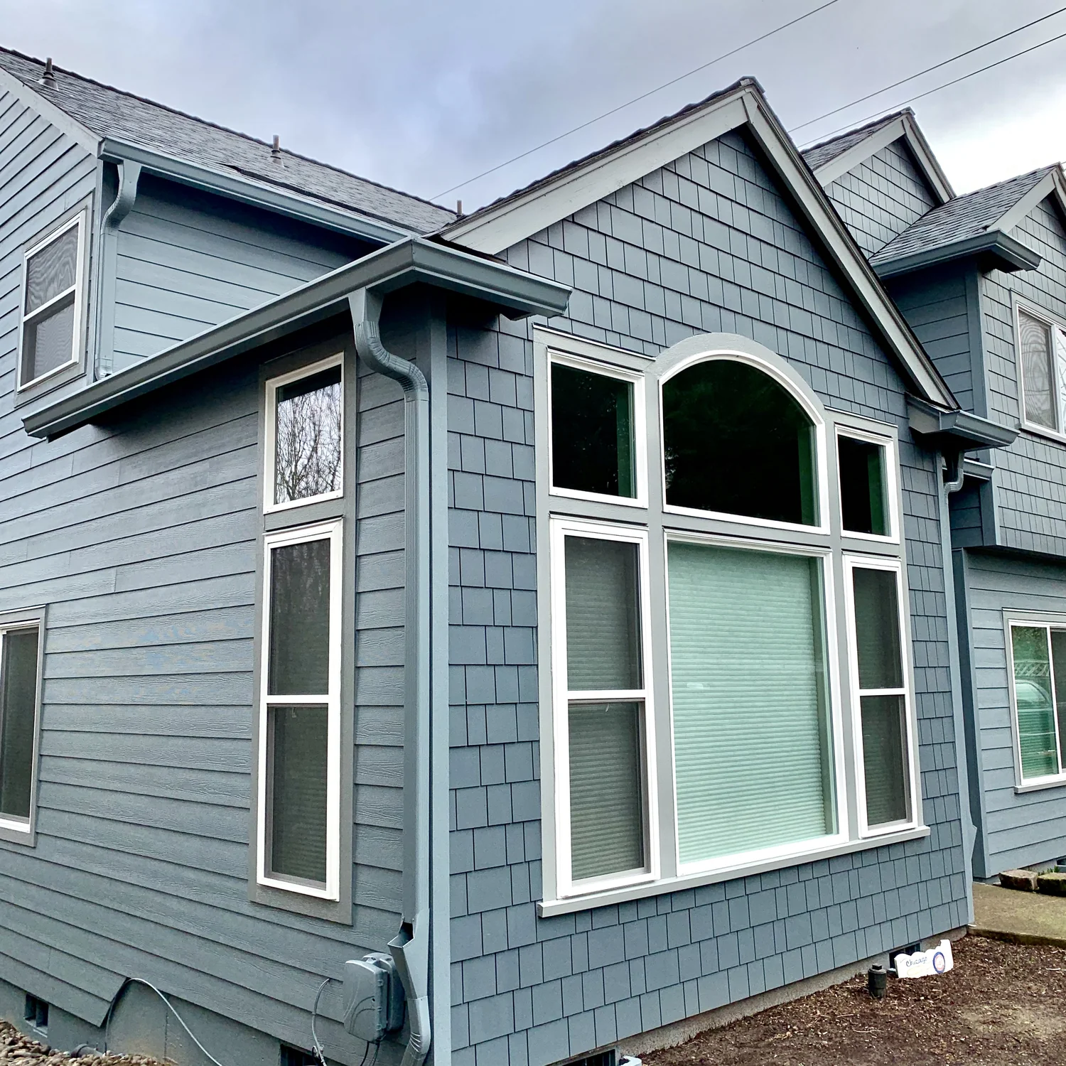 Red outbuilding gutter and downspout in a wooded Pacific Northwest yard, Brush Prairie WA area