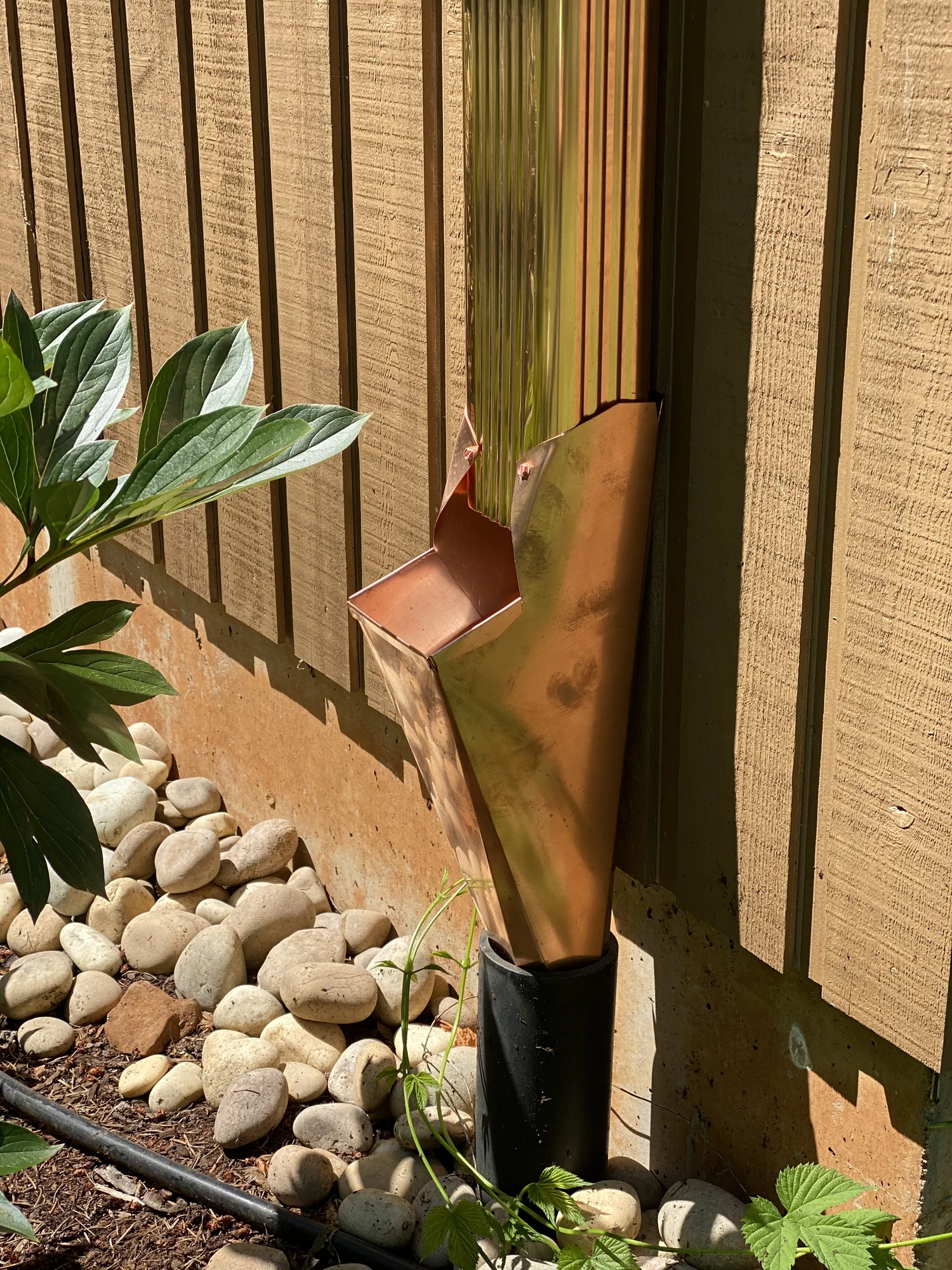 Copper downspout with conductor head and river rock siding, Orchards WA area