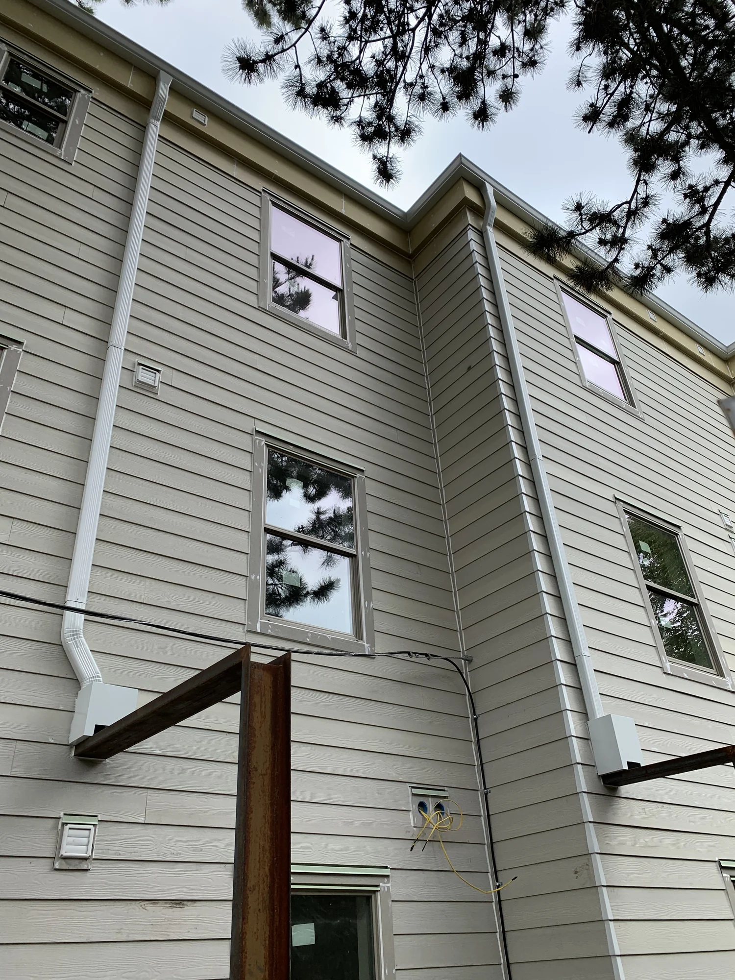 Green downspout and brick porch residential gutter detail, Woodland WA area
