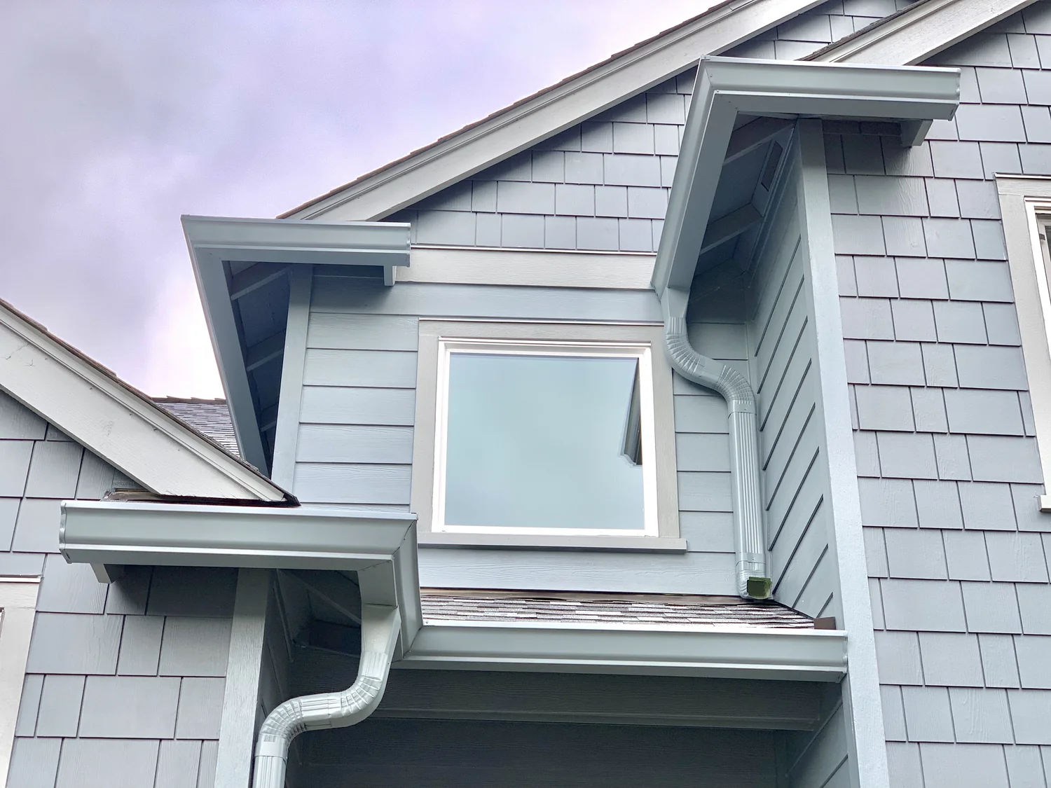 Two-story Clark County WA home with white gutters, roof drainage, and autumn leaves near Woodland